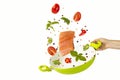 Throw the fish and vegetables with spices into the green frying pan. objects on white background. Flying Food